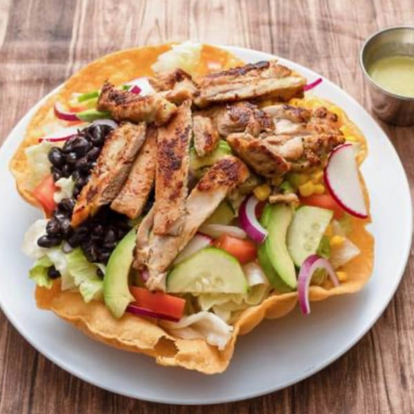 A La Ingrata Camden Mexican chicken taco salad in a crispy tortilla bowl with dressing.
